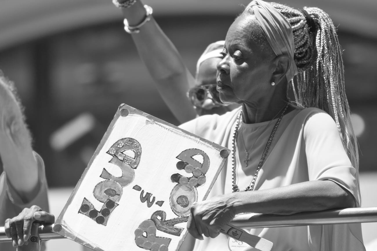 Older woman holding a "Loud and Proud" sign