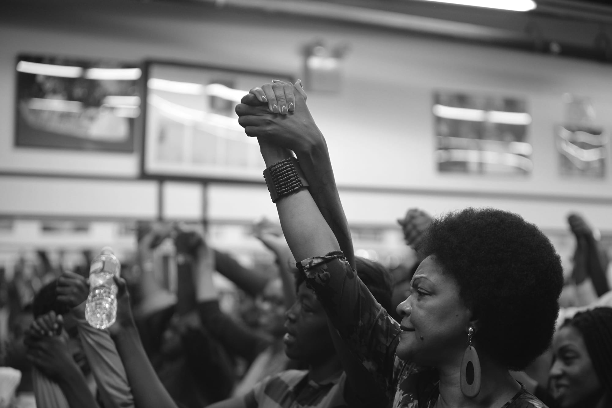 Women holding hands up in the air at an event