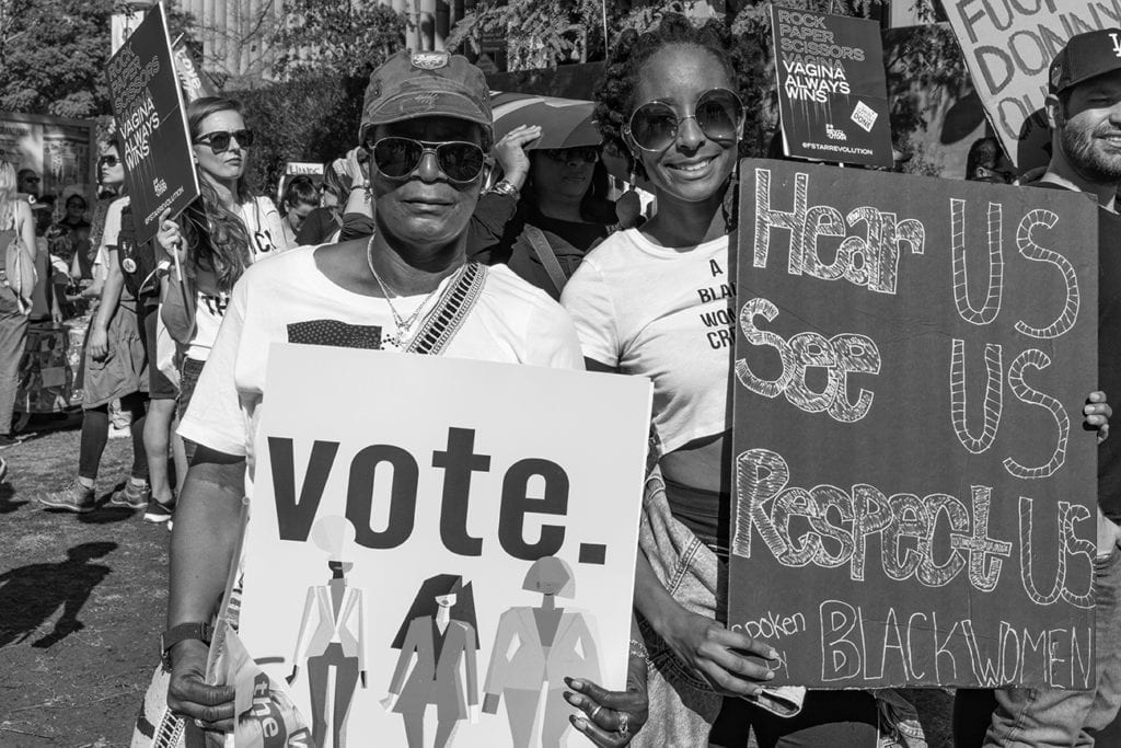 Older woman holding a "Loud and Proud" sign